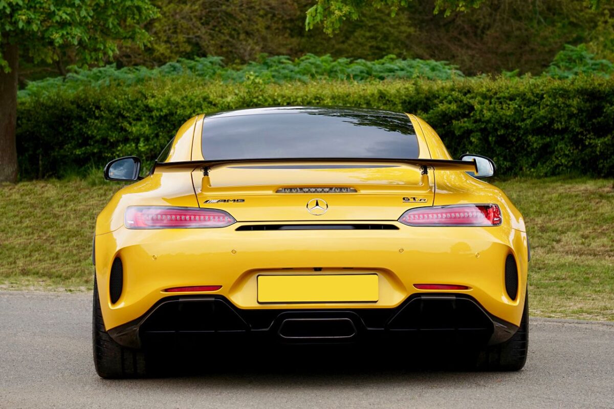 Simva Auto Yellow sports car parked outdoors, showcasing sleek design and vibrant color.